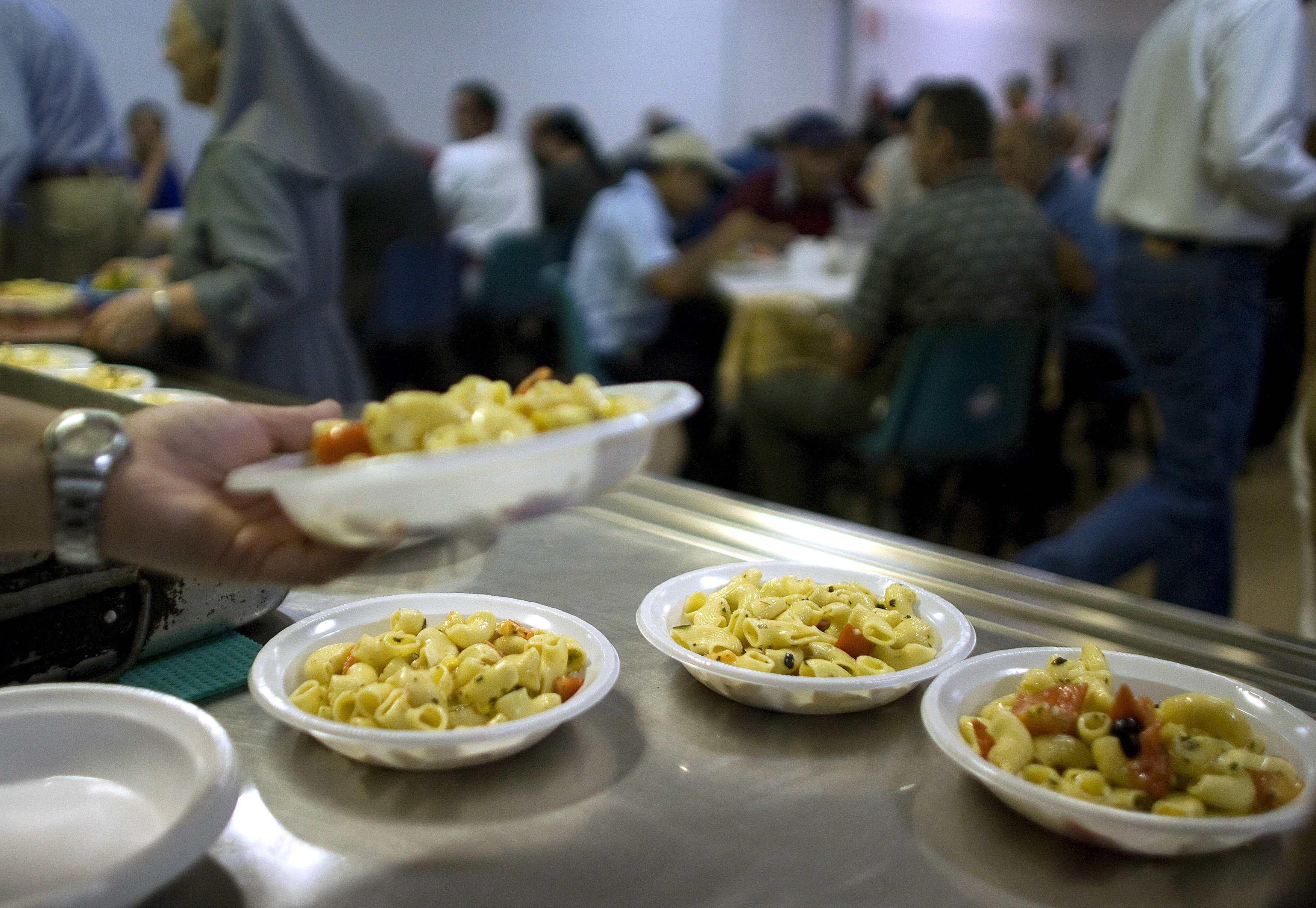 Free meals are served in a "soup kitchen" run by the Sant'Egidio Christian community in Rome September 17, 2008. The euro zone's third largest economy, Italy has been one of its most sluggish performers for more than a decade, and has suffered more than most of its partners from surging oil prices, a strong currency and the international slowdown. Statistics show that Italy is growing older and poorer while the economy underperforms its European peers.    To match feature FINANCIAL-ITALY/POOR     REUTERS/Tony Gentile        (ITALY)